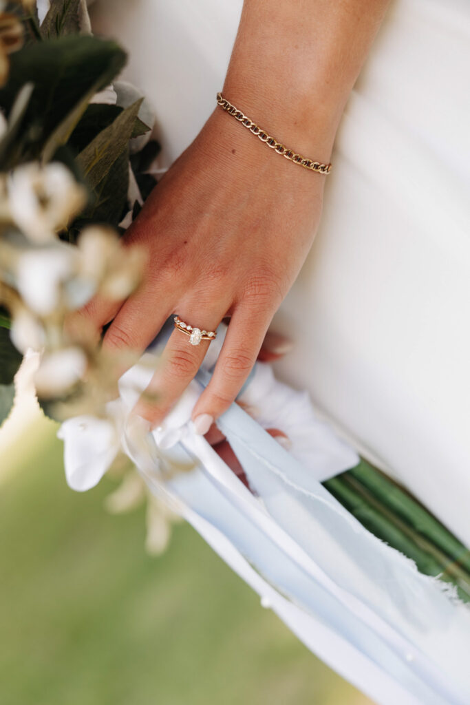elegant close up photo of a bride holding onto her bouquet, with focus on her markey ring